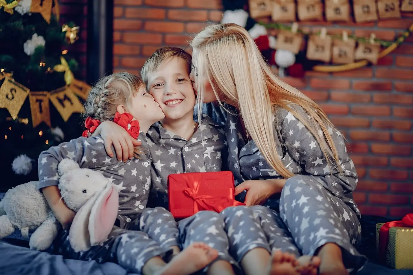Eine Familie sitzt auf einem Bett.
